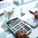 image of person calculating the cost of dental treatment.