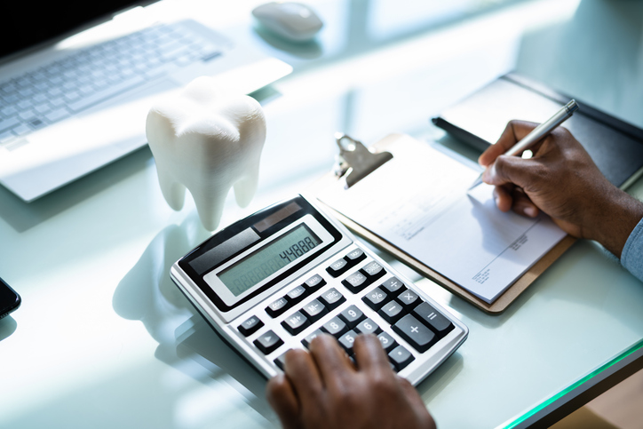 image of person calculating the cost of dental treatment.